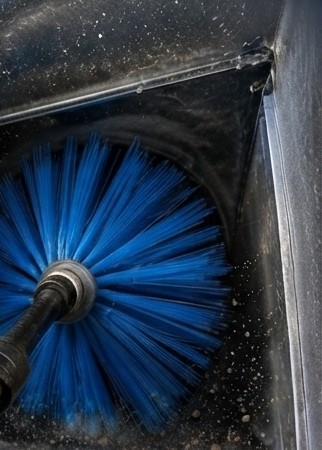 Rotary brush cleaning the inside of a dust-coated AC duct in a Dubai home